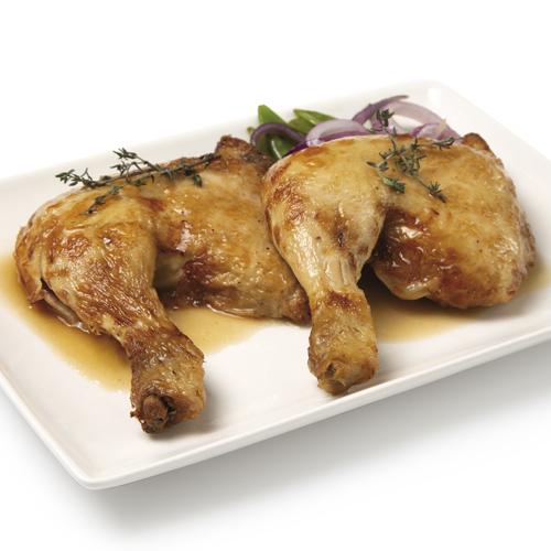 Contramuslo pollo Dos contramuslos de pollo sobre plato blanco