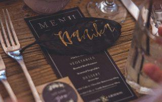 Menú de restaurante sobre mesa y junto a cubiertos