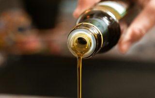 Aceite de oliva virgen extra vertiéndose desde botella