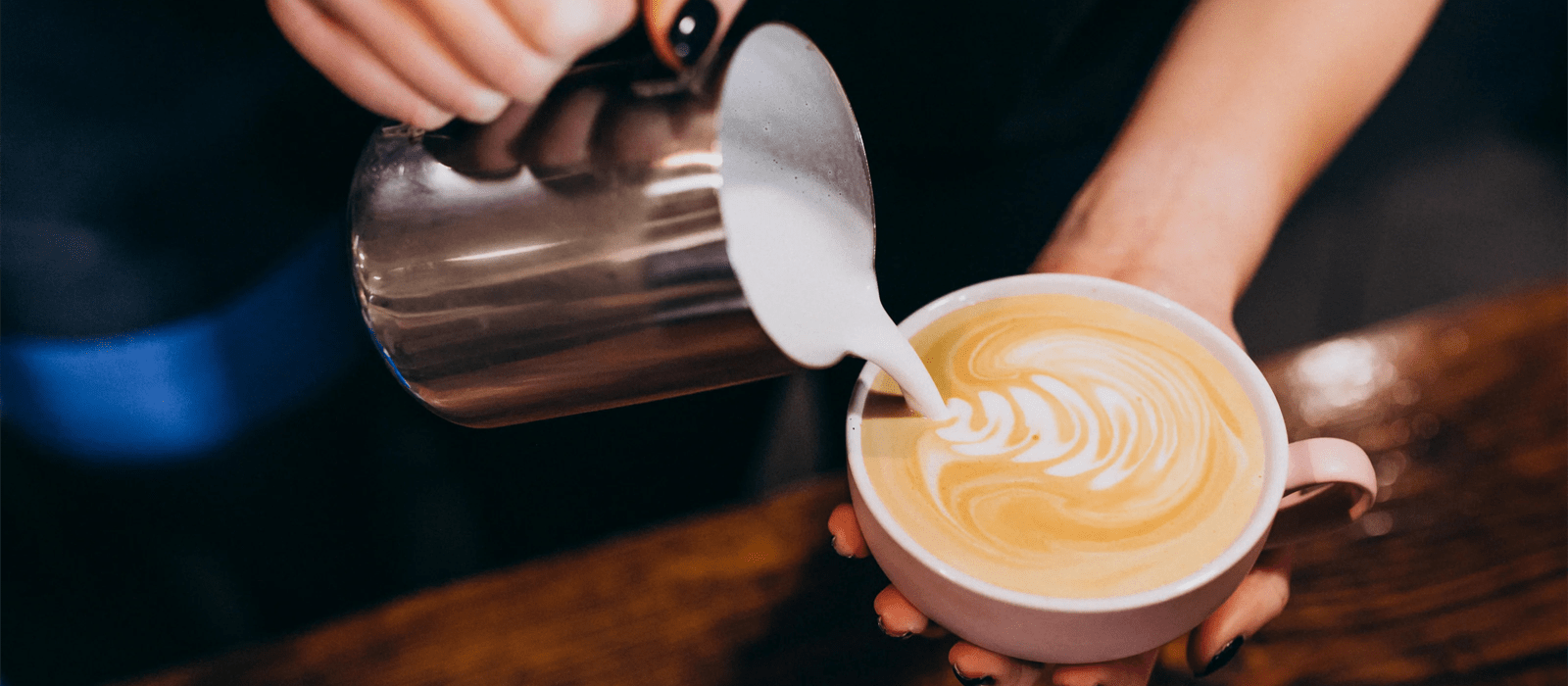 Barista vertiendo leche sobre café